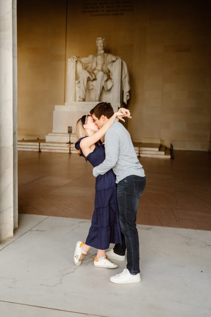 Married couple embrace and kiss in front the Lincoln Station in Washington DC along the National Mall.