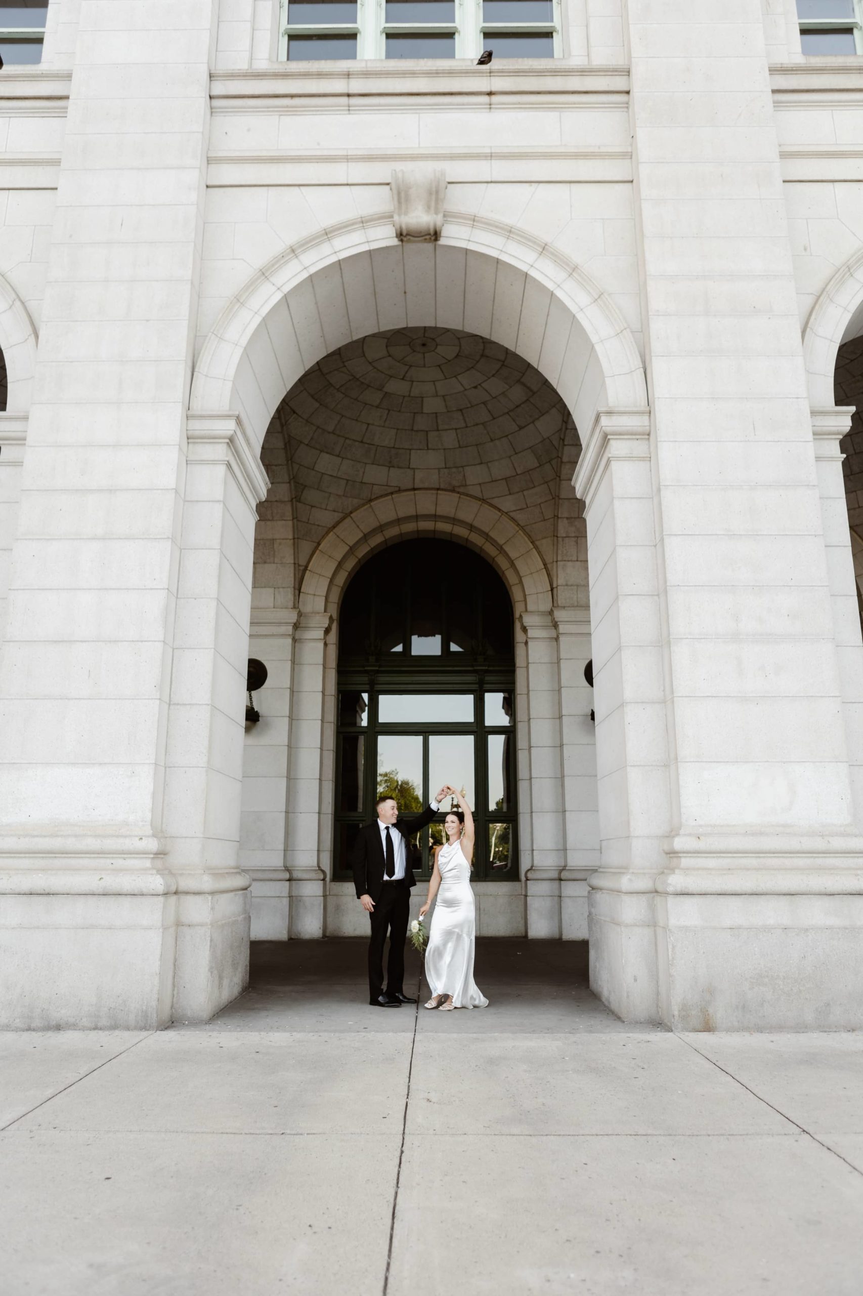 Groom spins bride under an arch at Union Station, DC