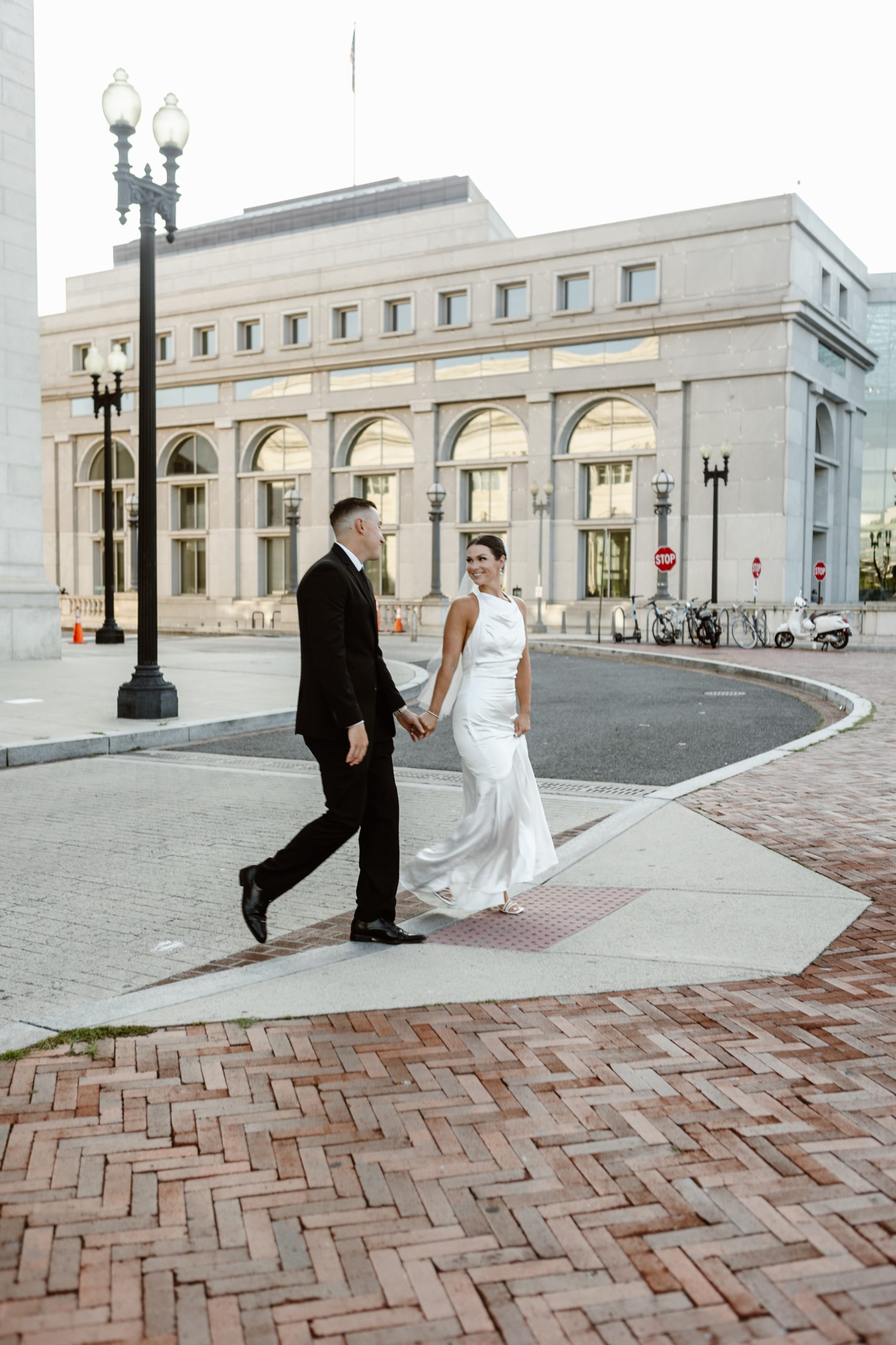 Wedding couple walks across the street at Union Station, DC. 
