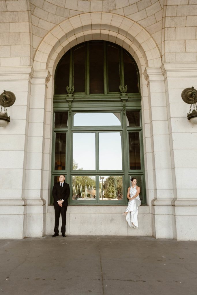 Bride and groom sit on opposite sides of union Station windowsill during their Washington DC elopement wedding. 