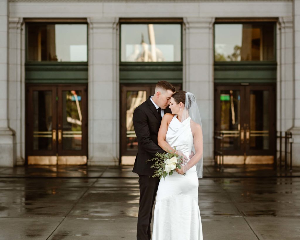 Bride and groom stand at the entrance of Union Station, Washington DC after their wedding.
