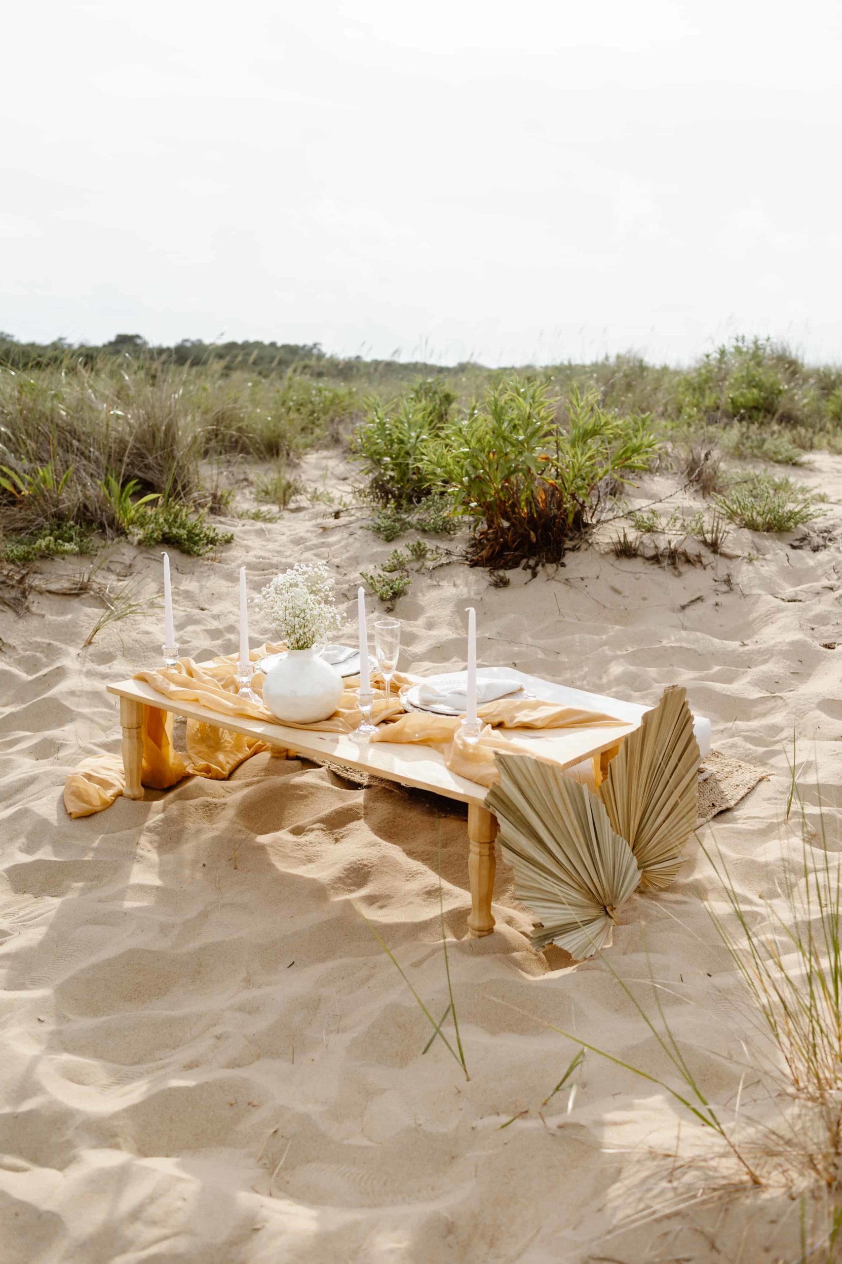 Virginia Beach Bohemian luxury picnic in the sand with flowers and candles.