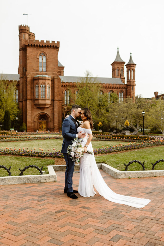 bride and groom hugging in front of the smithsonian castle