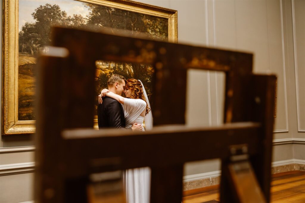 bride and groom hugging in front of a painting during their elopement at the national gallery of art in washington dc