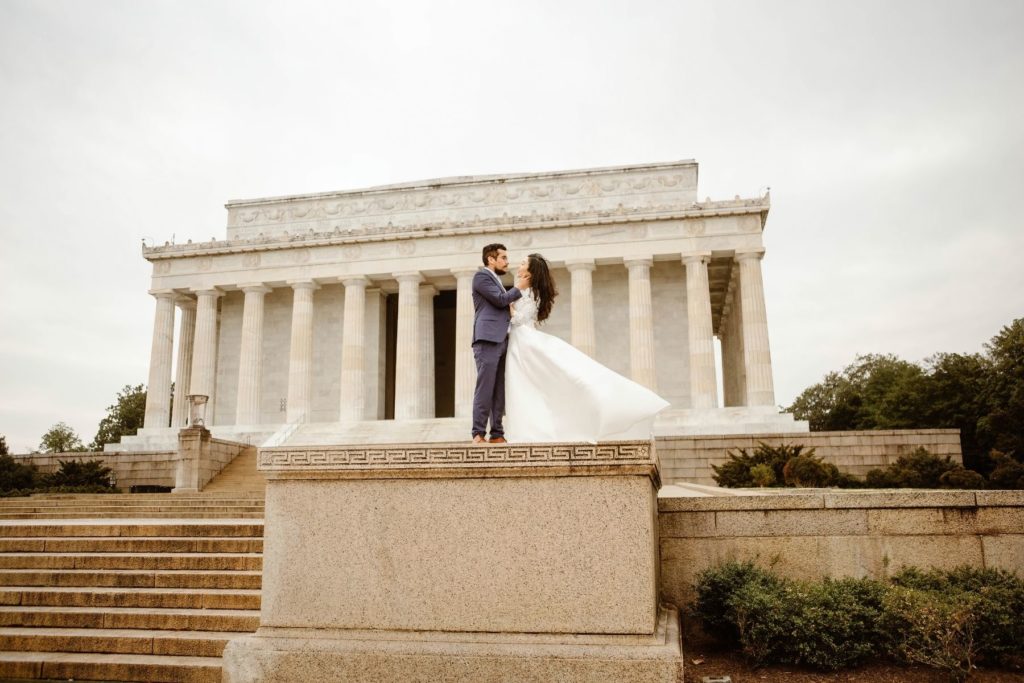Bride and groom stand on in front of the Lincoln Memorial in Washington DC during their elopement.