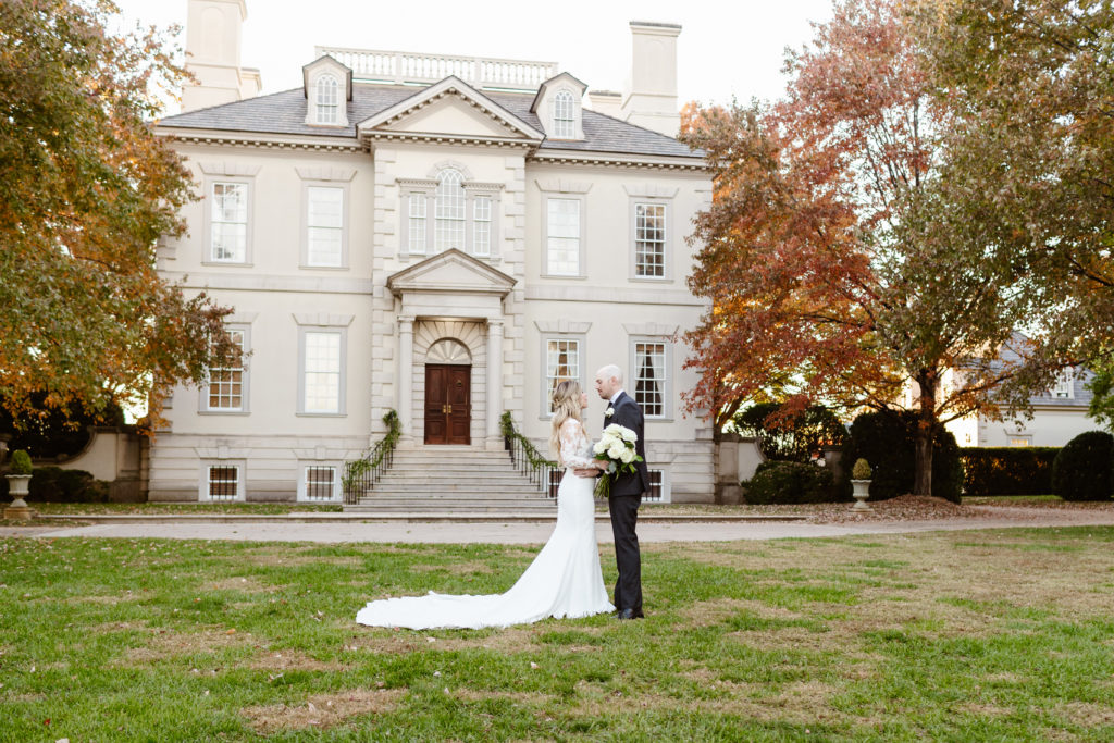 Wedding Couple stand in the grass in front of Great Marsh Estate, Virginia