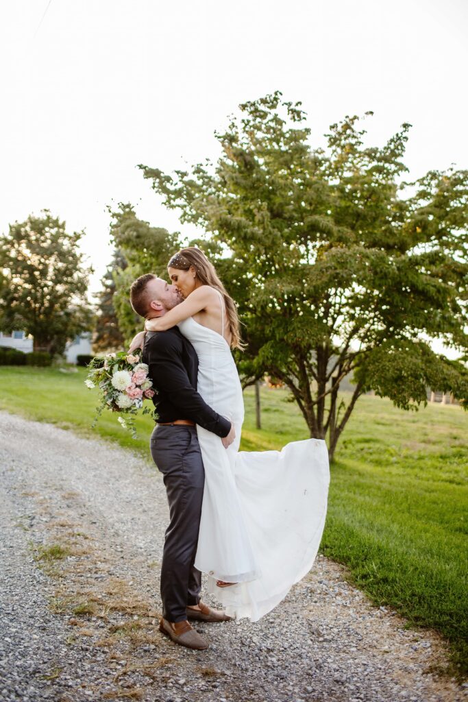 groom picks bride up and kisses her during their Maryland elopement day. 