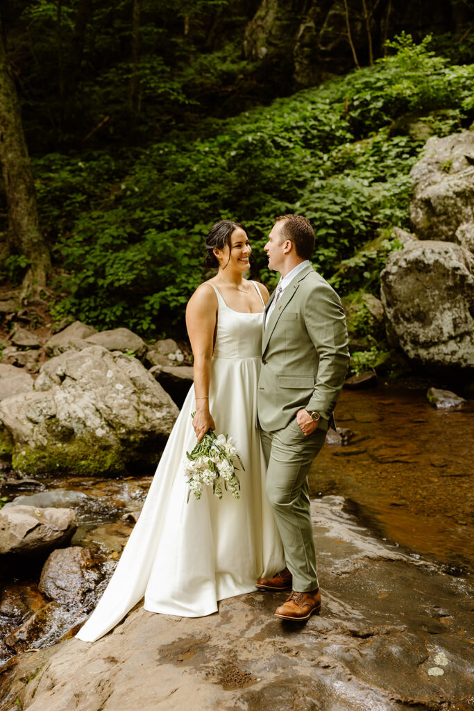 bride and groom at a waterfall during their shenandoah national park elopement