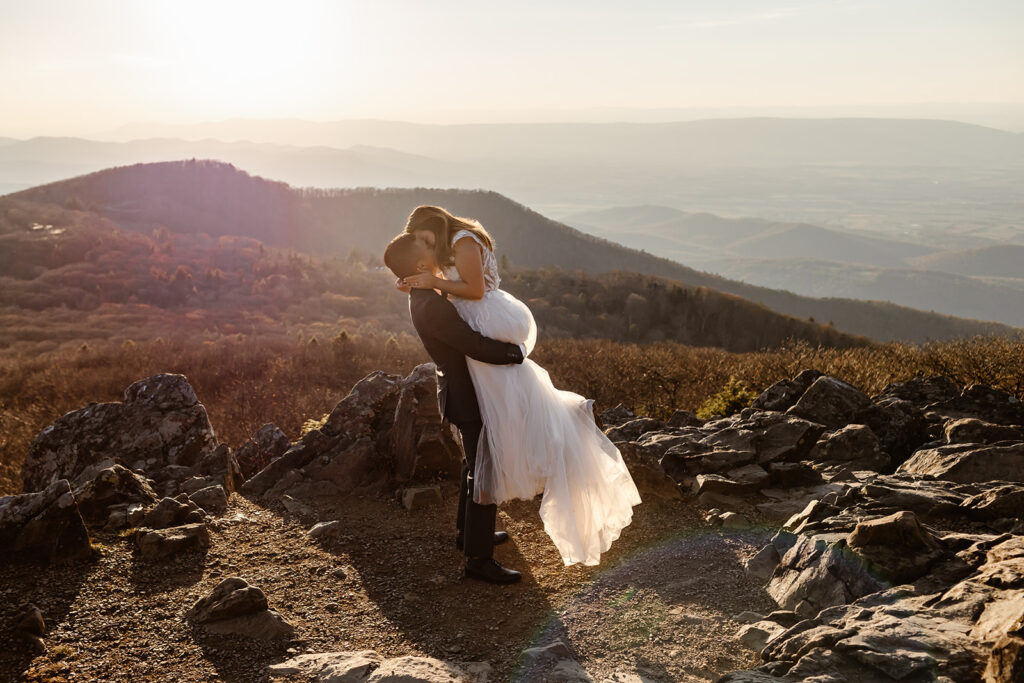 playful elopement couple on a mountain overlook during sunset for their golden hour moments in Shenandoah National Park