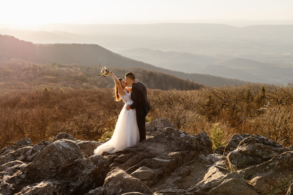 playful elopement couple on a mountain overlook during sunset for their golden hour moments in Shenandoah National Park