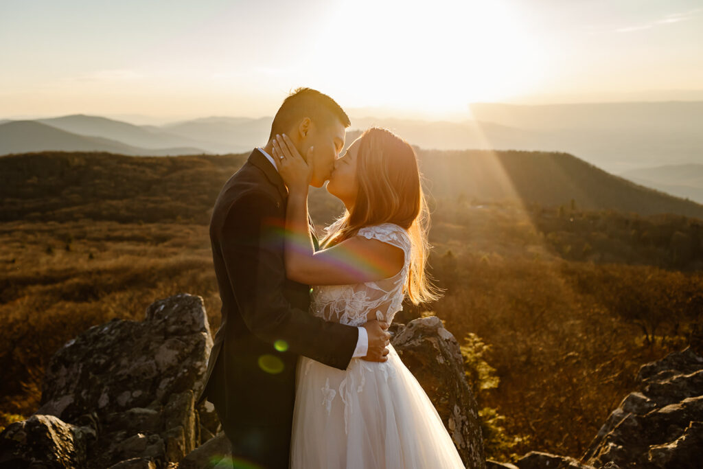 bride and groom kissing during the golden hour in shenandoah national park
