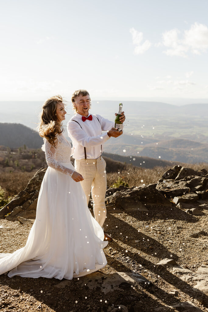 bride and groom popping champagne as they celebrate their elopement