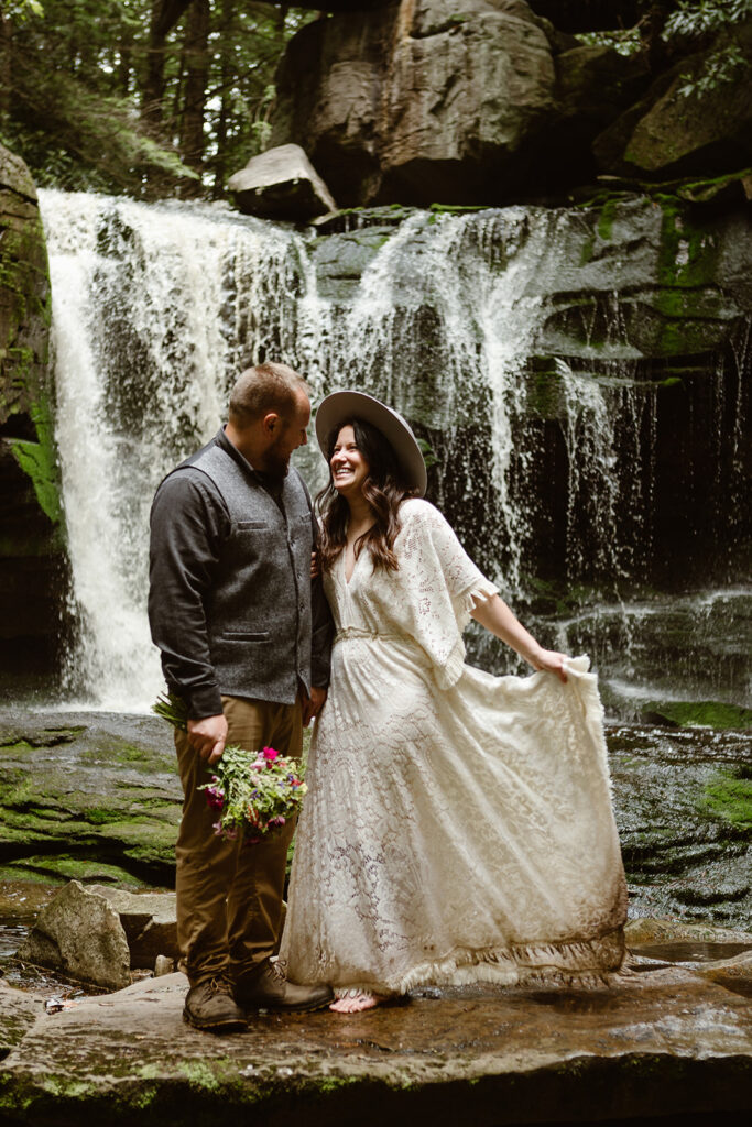 the wedding couple standing in the waterfall for their National Park Elopement