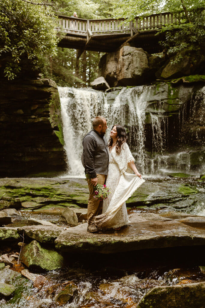 the wedding couple posing for their elopement photos under the waterfall 