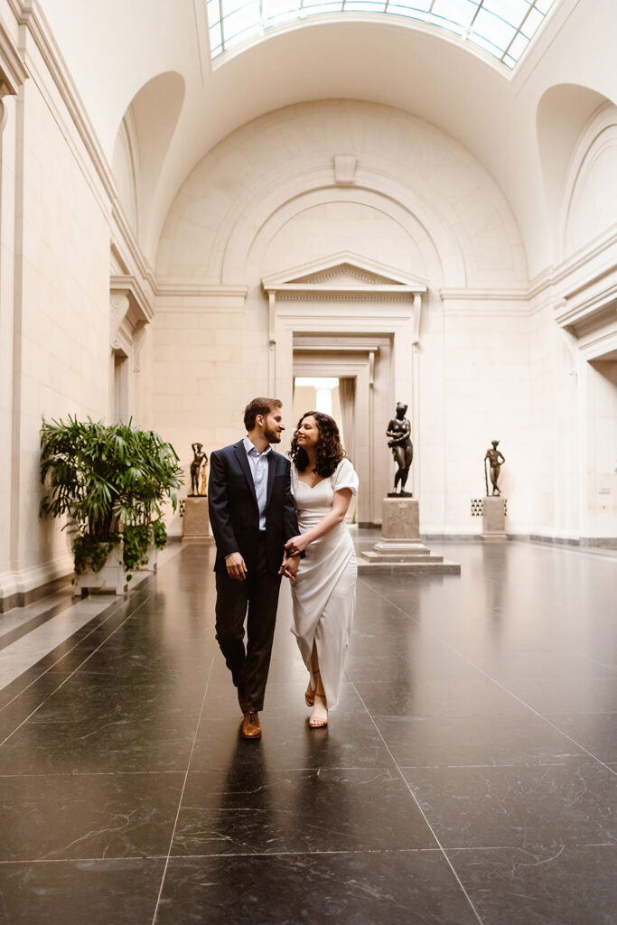 the engaged couple strolling through the National Gallery of Art as they hold hands