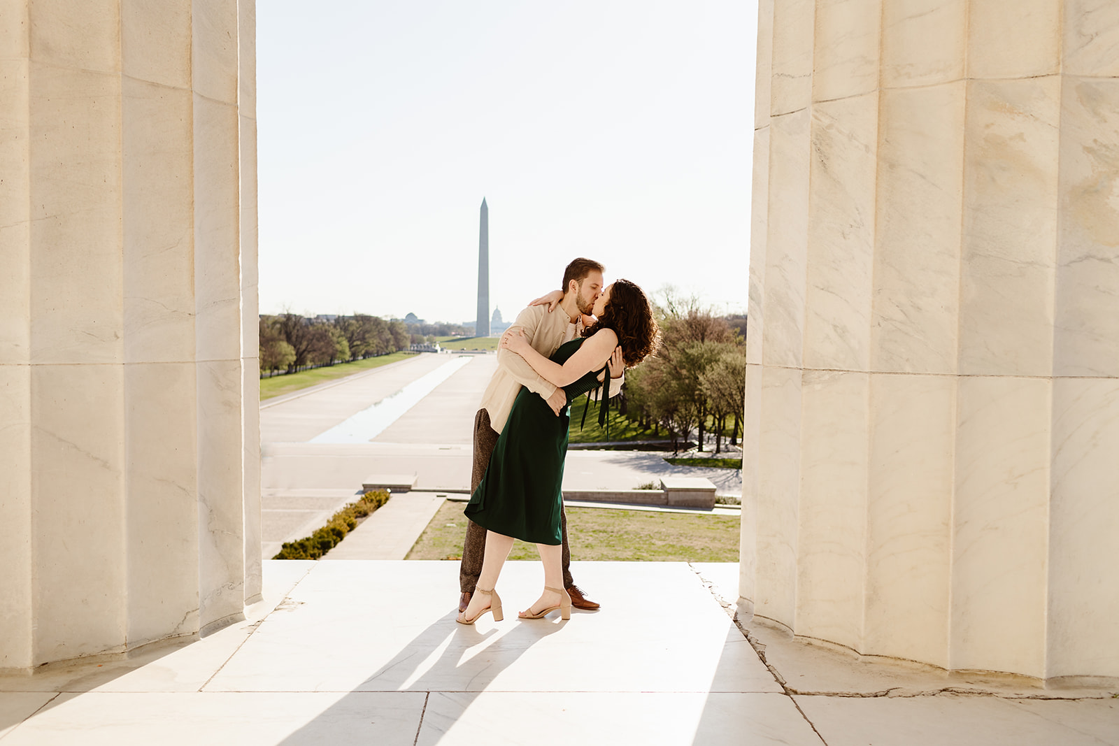 The engaged couple posing at the Lincoln Memorial for their DC engagement photos.