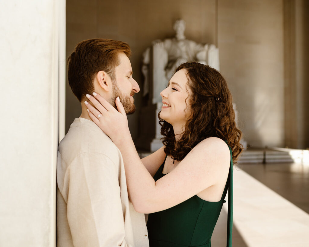 The engaged couple embracing at the Lincoln Memorial for their Washington DC engagement photos in the spring.