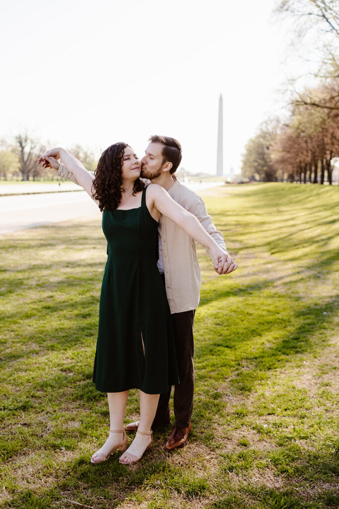 The engaged couple doing the airplane couple photography pose for playful engagement photos in Washington DC
