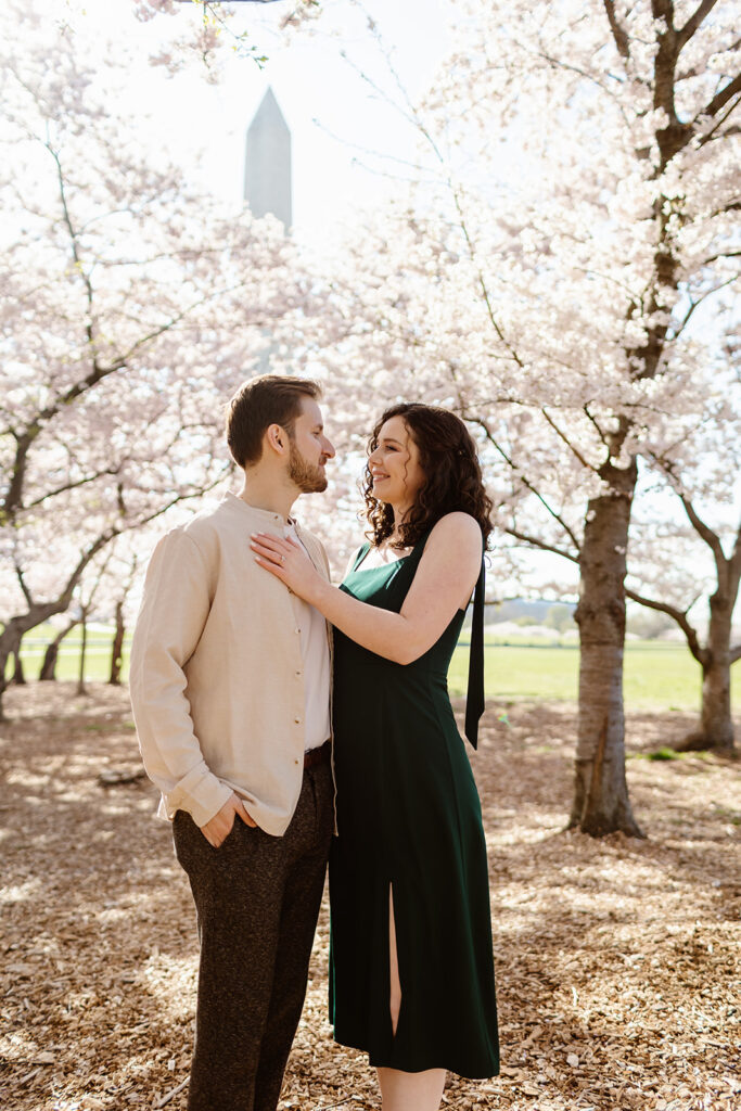 The engaged couple posing in the cherry blossoms for romantic spring engagement photos in Washington DC