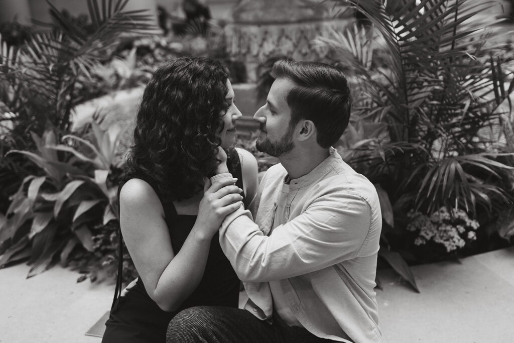 The engaged couple sitting closely together in a black and white DC engagement photo.