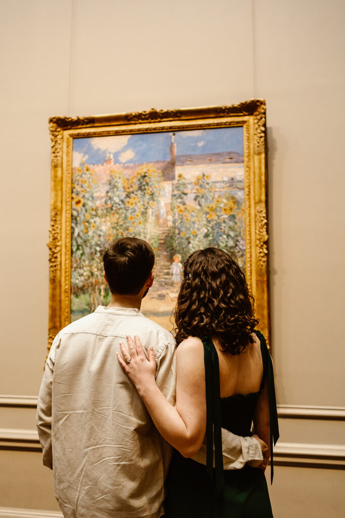 The couple standing together as they admire the art at the National Gallery of Art during their engagement session