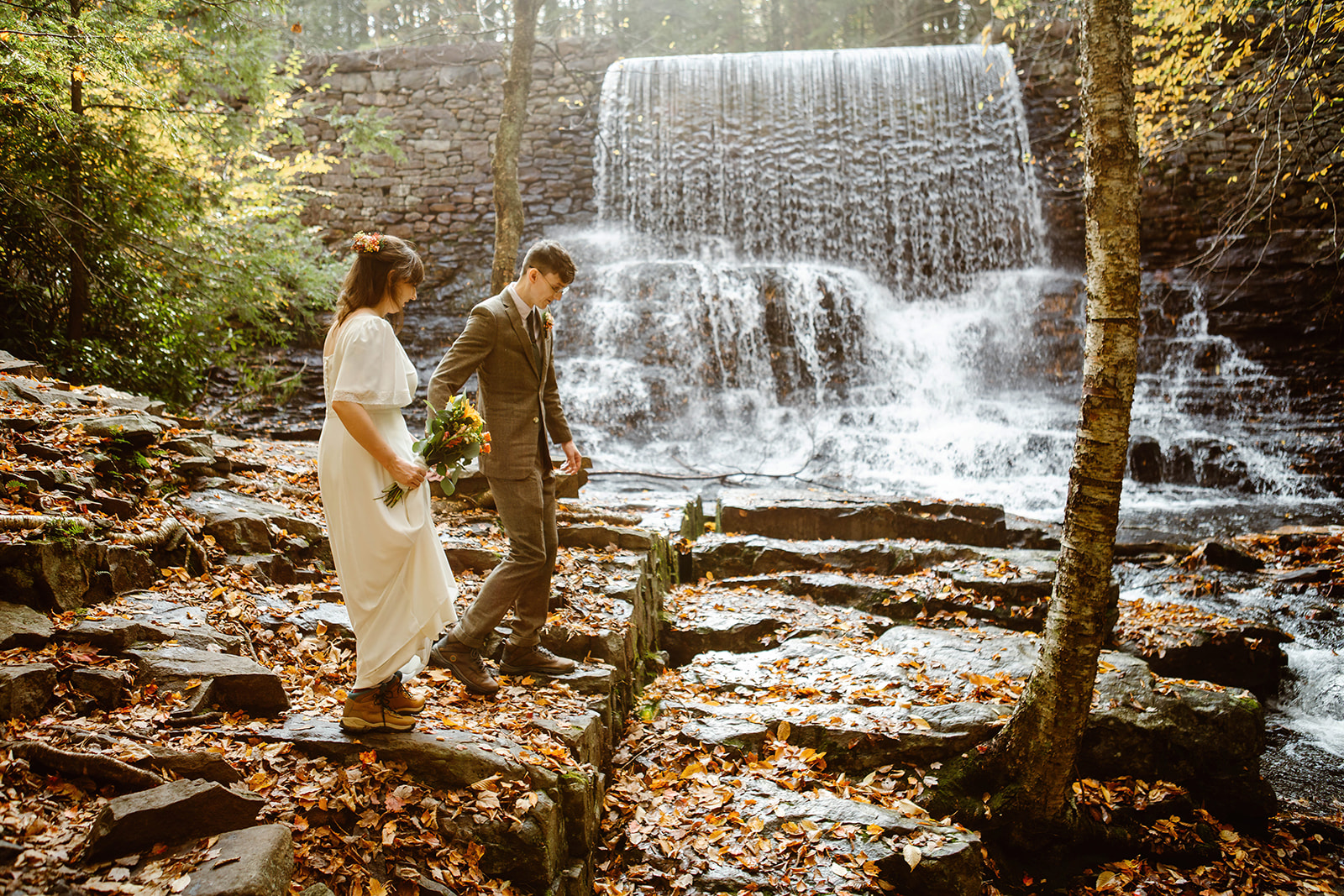 Bride and groom walking through the woods for their elopement