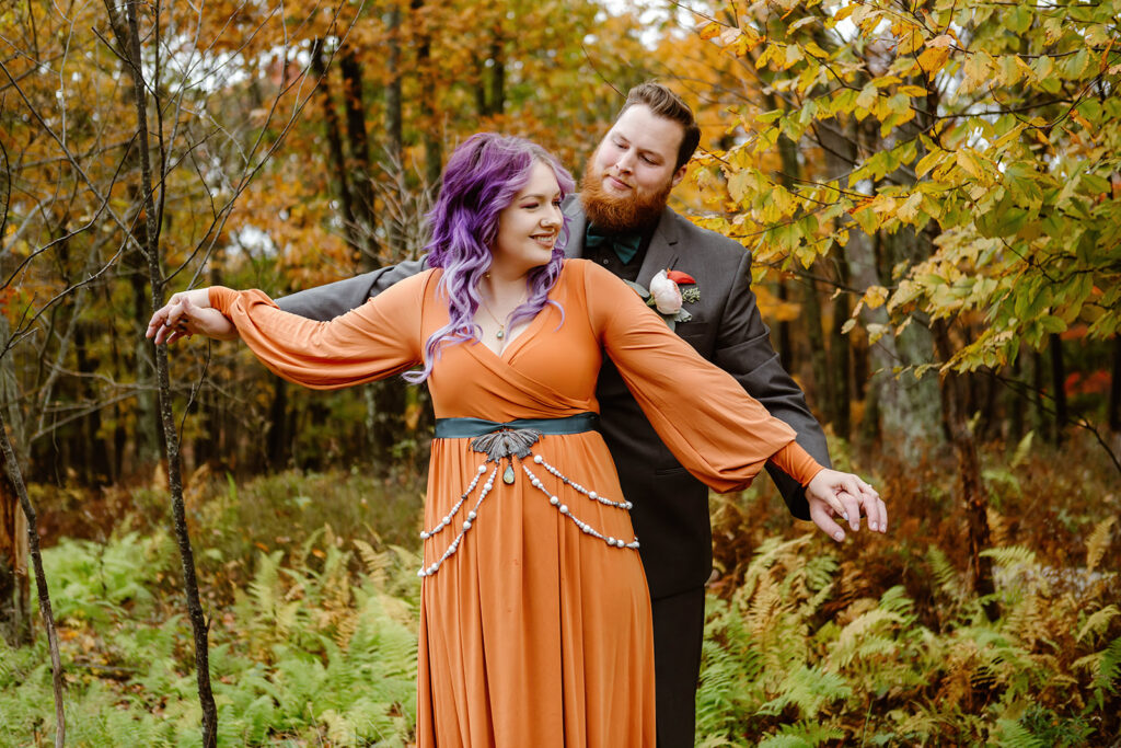 the engaged couple doing the airplane pose for fall elopement photos