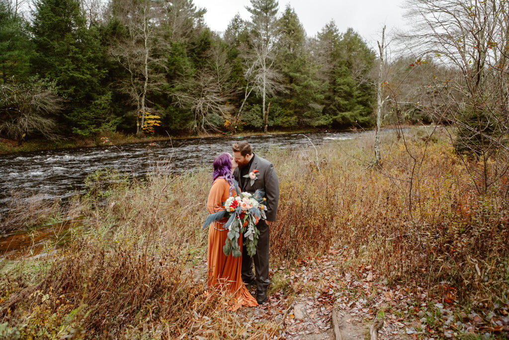 the wedding couple kissing at the state park before their elopement ceremony