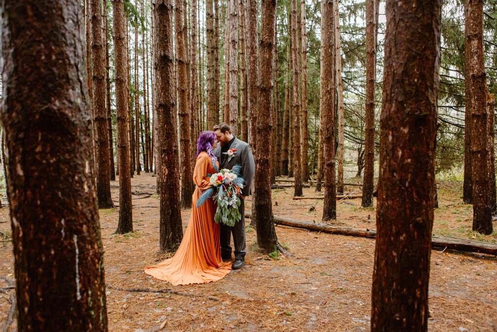 the wedding couple pressing their foreheads together in the woods for elopement photos
