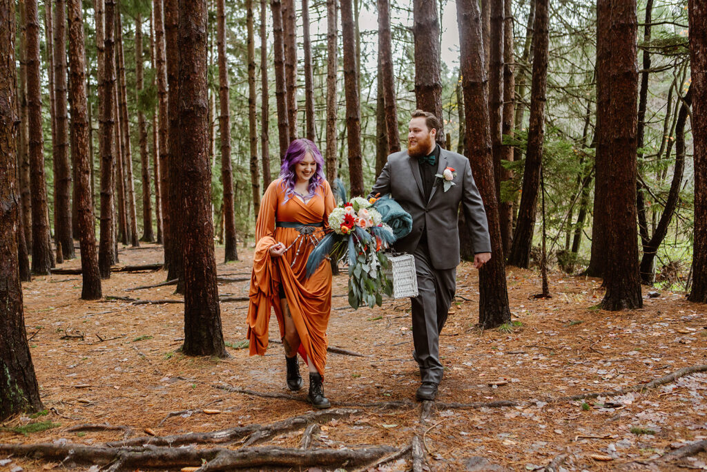 the wedding couple walking through the woods together