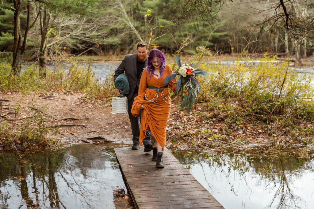 the bride and groom crossing over the bridge during their fall elopement