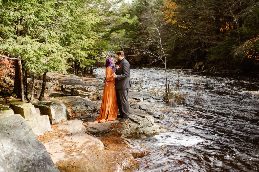 the wedding couple standing near the river for their elopement wedding photography