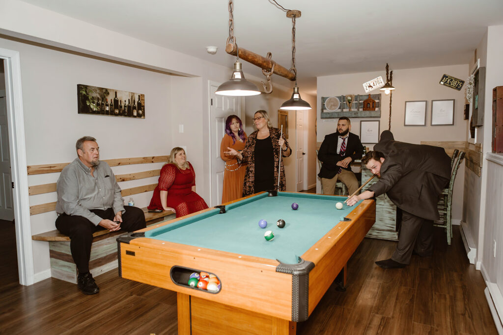 the wedding couple and their guest playing pool at the airbnb during the fall elopement