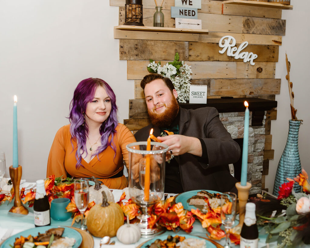 the elopement couple lighting a candle during their reception at an airbnb