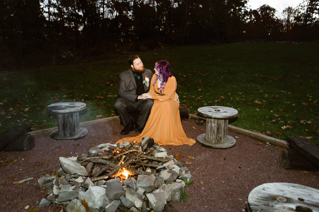 the bride and groom at their airbnb for a bonfire during their fall elopement