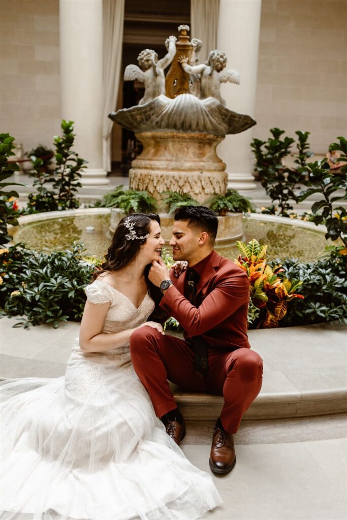 the bride and groom sitting at the fountain during their DC elopement