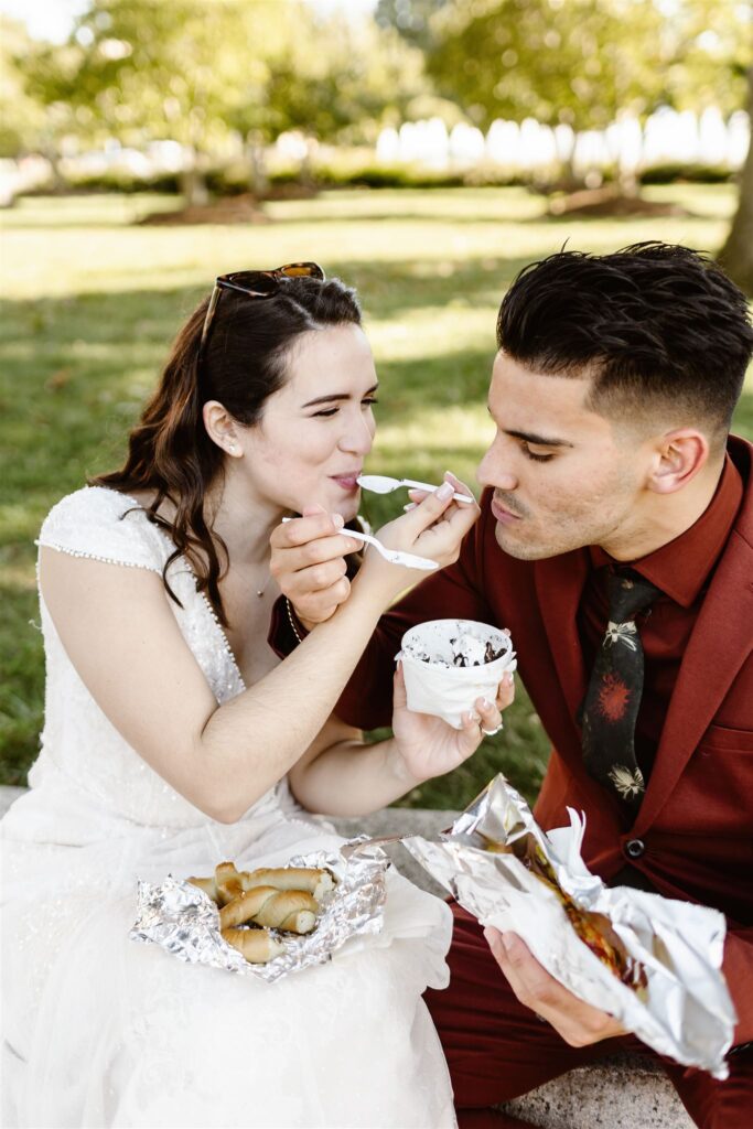 the bride and groom eating ice cream together for their wedding