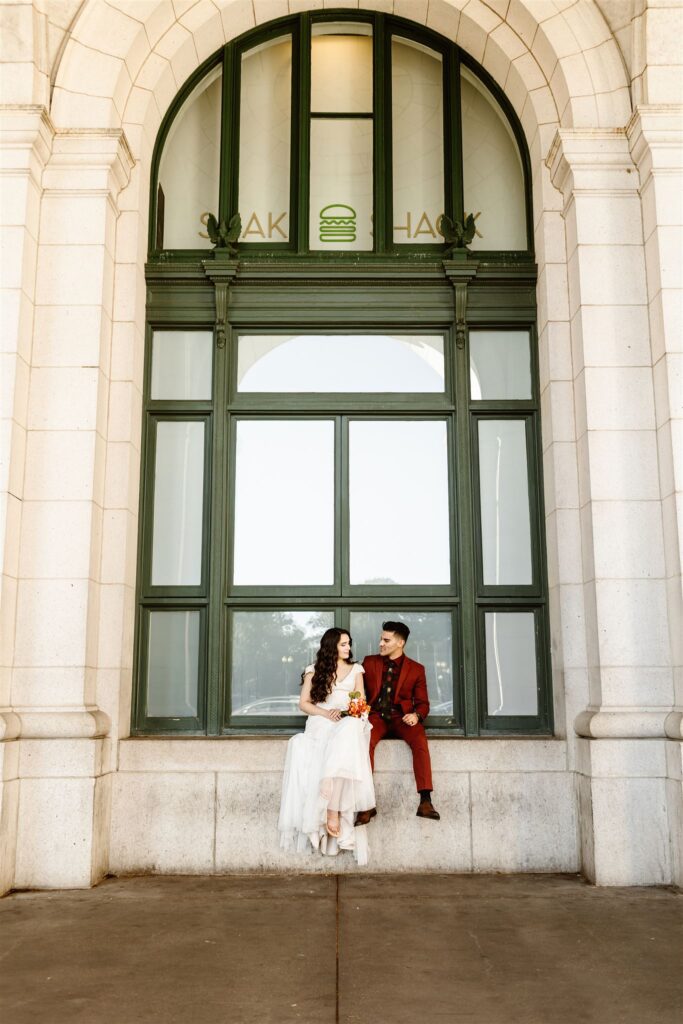 the bride and groom posing in front of the windows for DC elopement photography