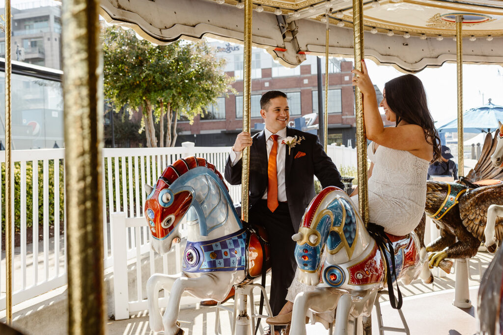 the wedding couple on a carousel for a fun elopement activity after their dc war memorial wedding ceremony