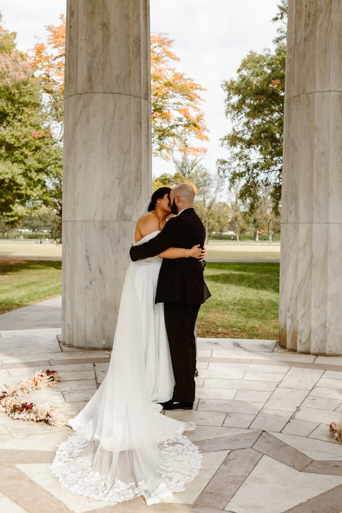 the wedding couple kissing at the dc war memorial during a wedding dance