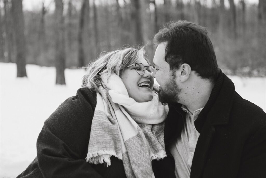 engaged couple playing in the snow for their winter engagement photos