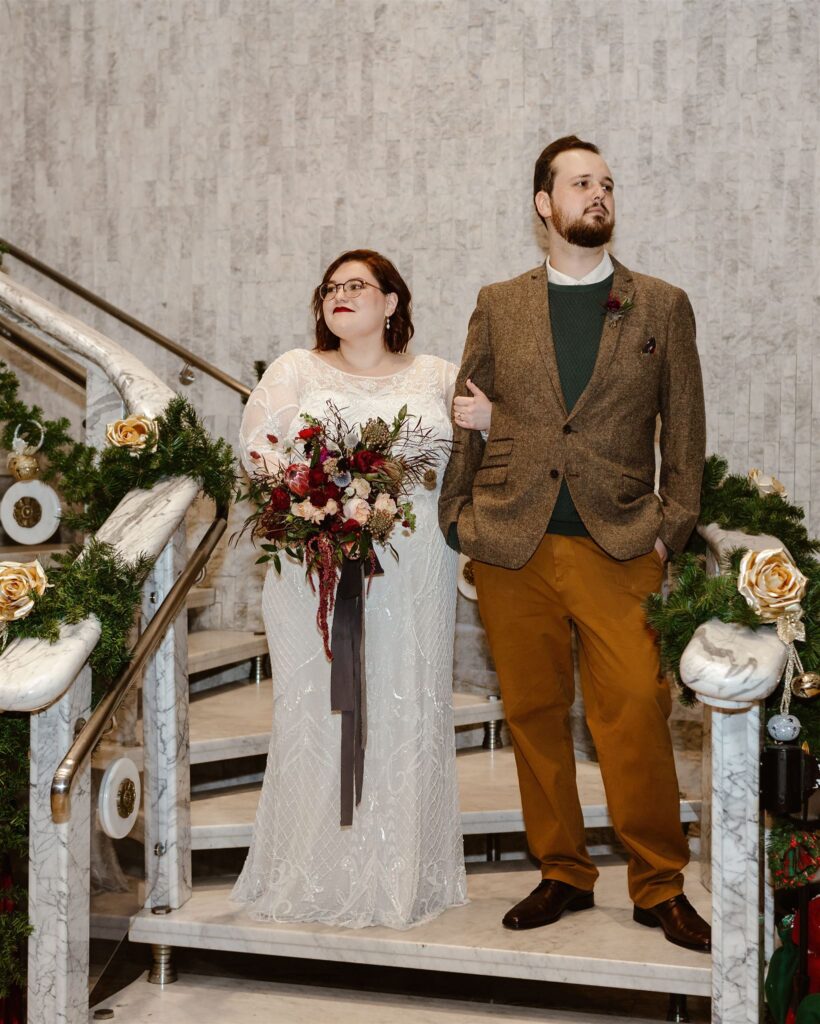 the wedding couple standing on the staircase