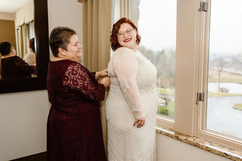 the bride puts on her wedding dress for her winter wedding