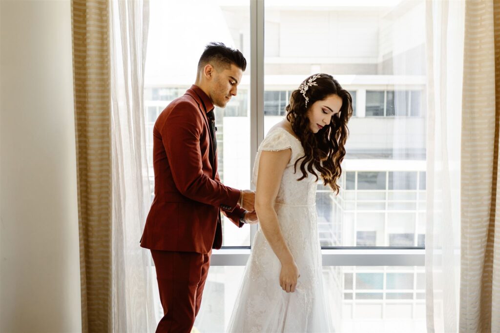 the groom zipping up the bride's dress during their Washington DC Elopement