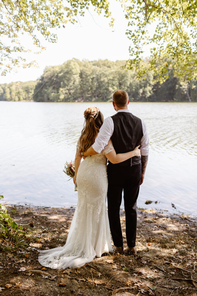 the bride and groom standing together along the lake at Seneca Creek State Park during their Maryland elopement