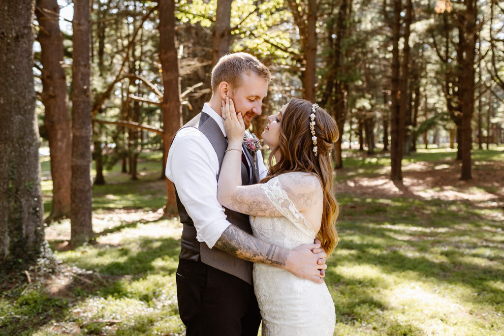 the bride and groom taking couples portraits in the pine trees at Seneca Creek State Park in Maryland.