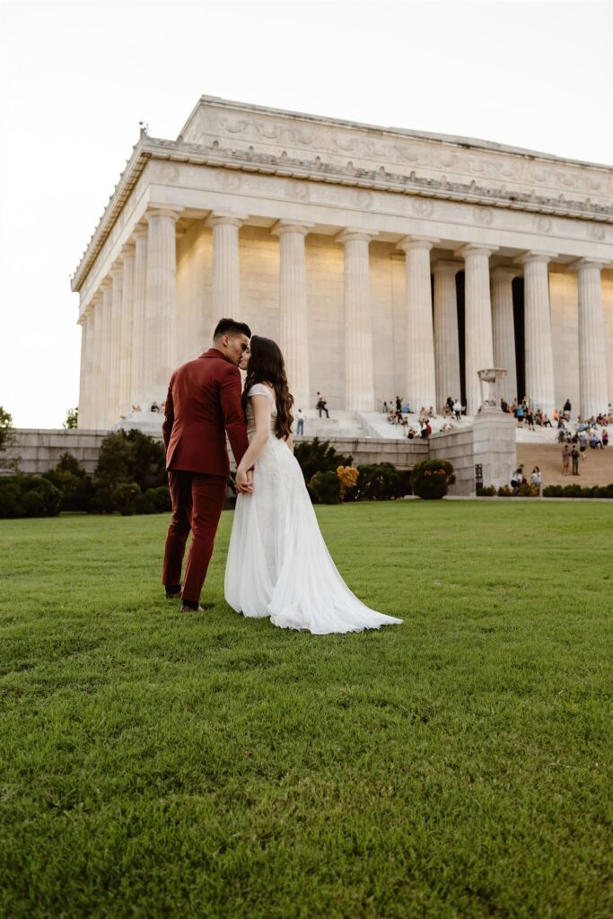 the wedding couple kissing in front of the Lincoln Memorial