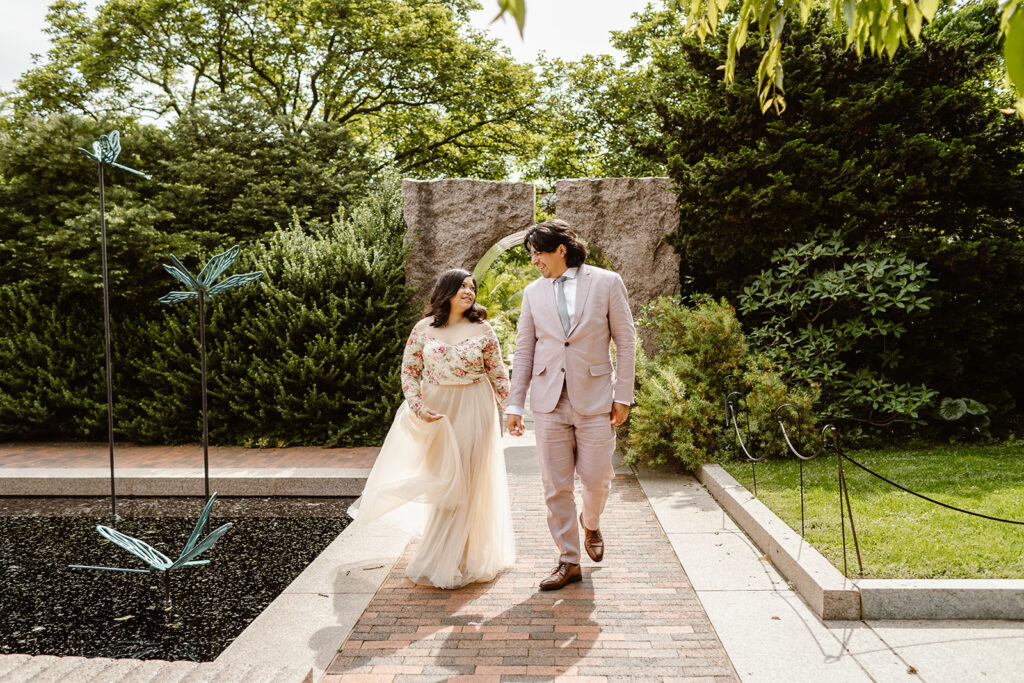 wedding couple holding hands and walking through the gardens in Washington DC