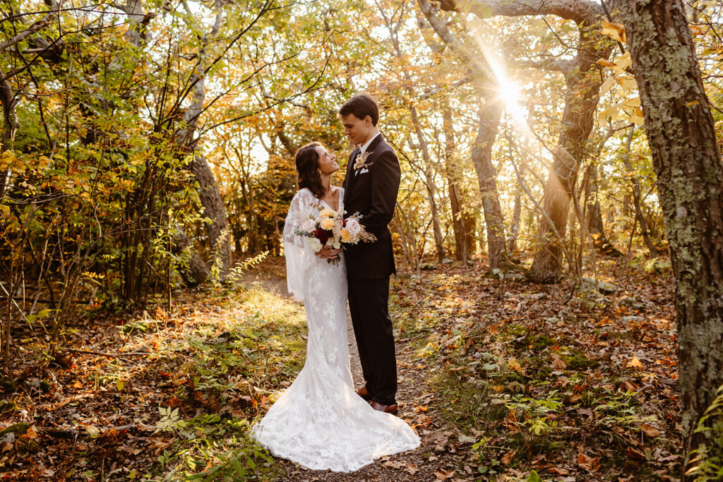 the wedding couple in the fall leaves for adventure elopement photos in during their Virginia elopement.