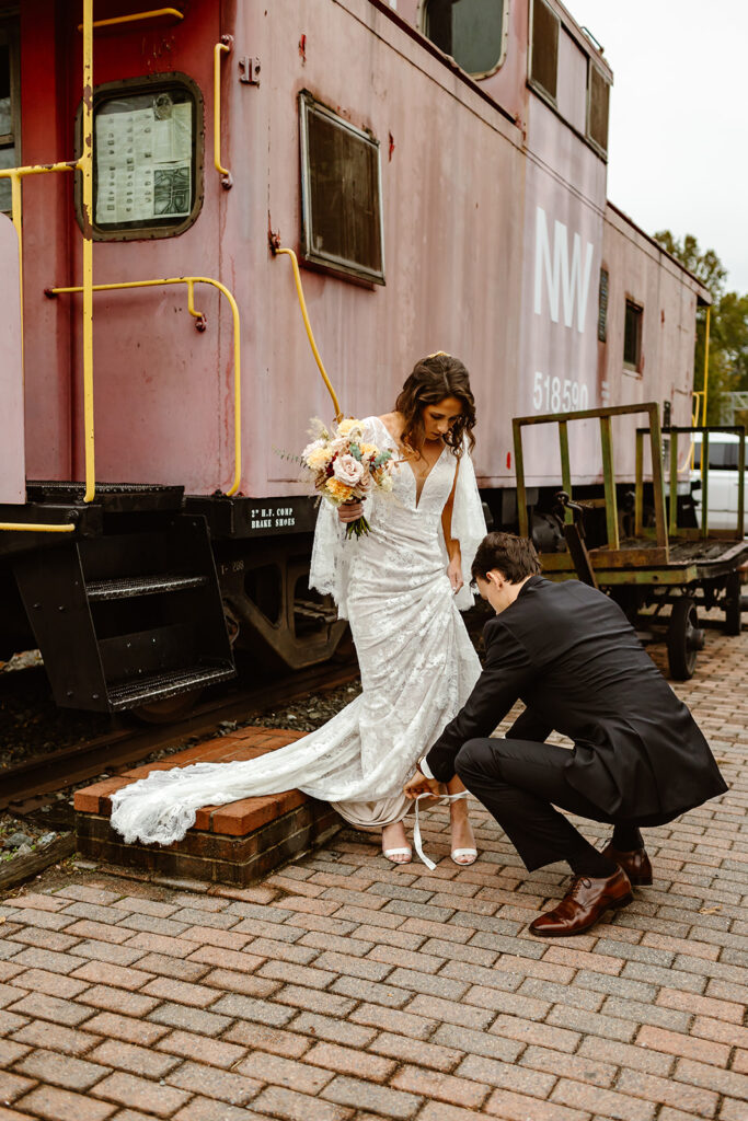 the groom fixing the bride's wedding shoes during their Virginia elopement